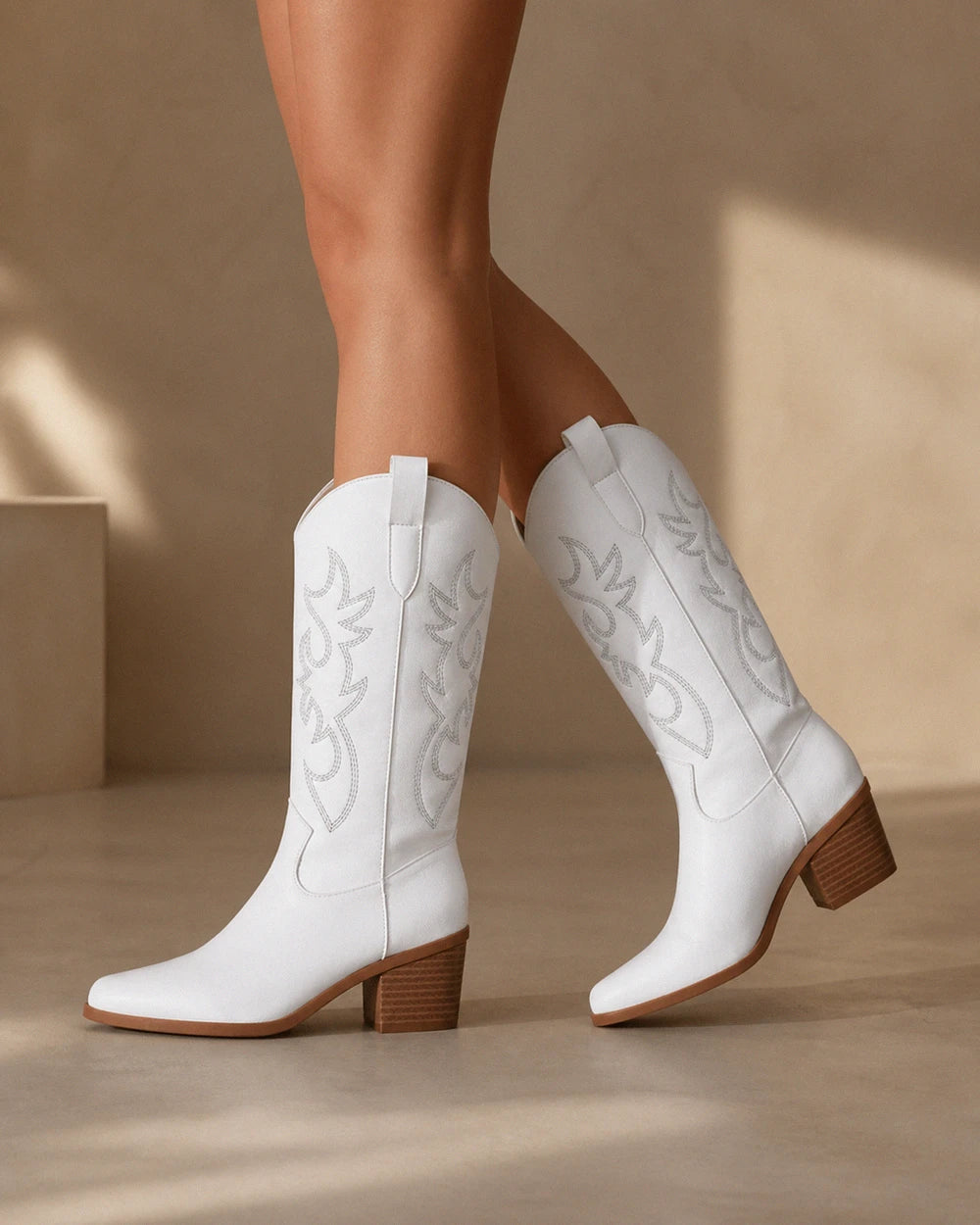 Exact plain white embroidered Western knee-high boots, walking view.