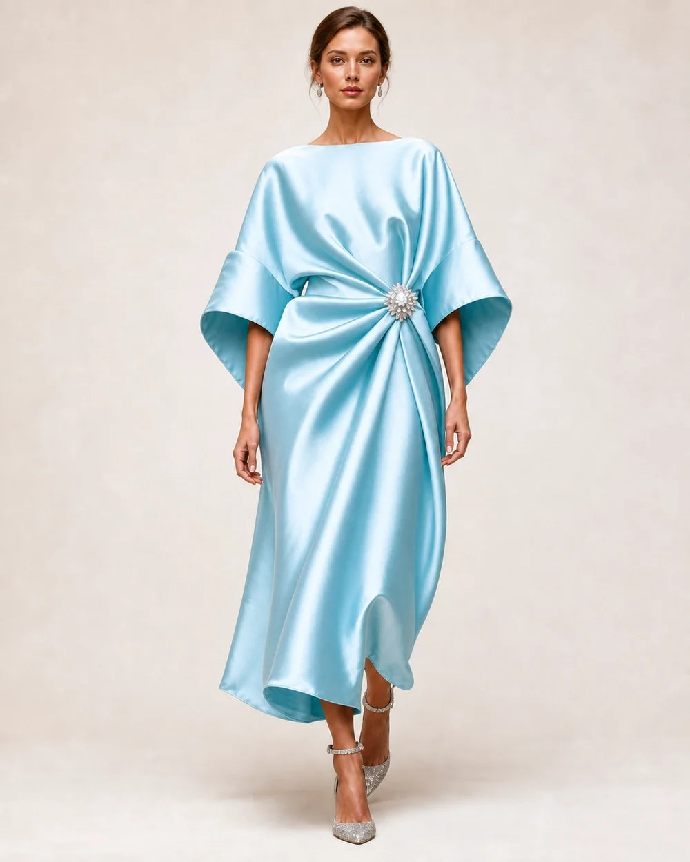 Women's turquoise satin midi dress with draped waist, crystal flower brooch and wide batwing sleeves.