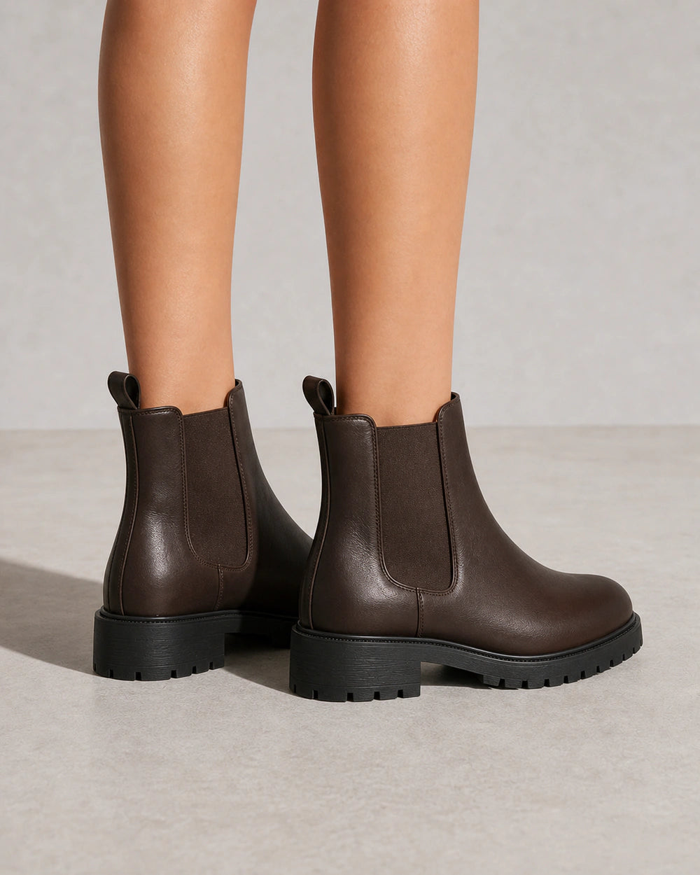 Women's chocolate brown lug-sole Chelsea boots, rear view.